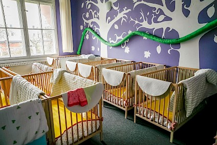 The minis sleeping room with purple colored accents and a soothing atmosphere