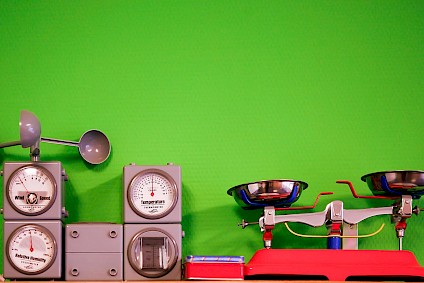 Weather station and scale in front of an apple-green wall