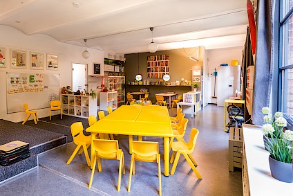 The cozy Einstein group room with yellow accents and lots of science to be explored