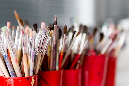Countless brushes in all sizes and shapes, in red cups, of course