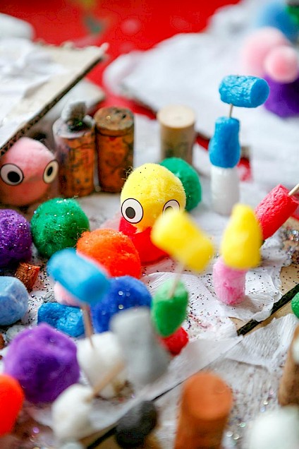 Little hand crafted figures made from brightly colored fabric balls and wobbly eyes